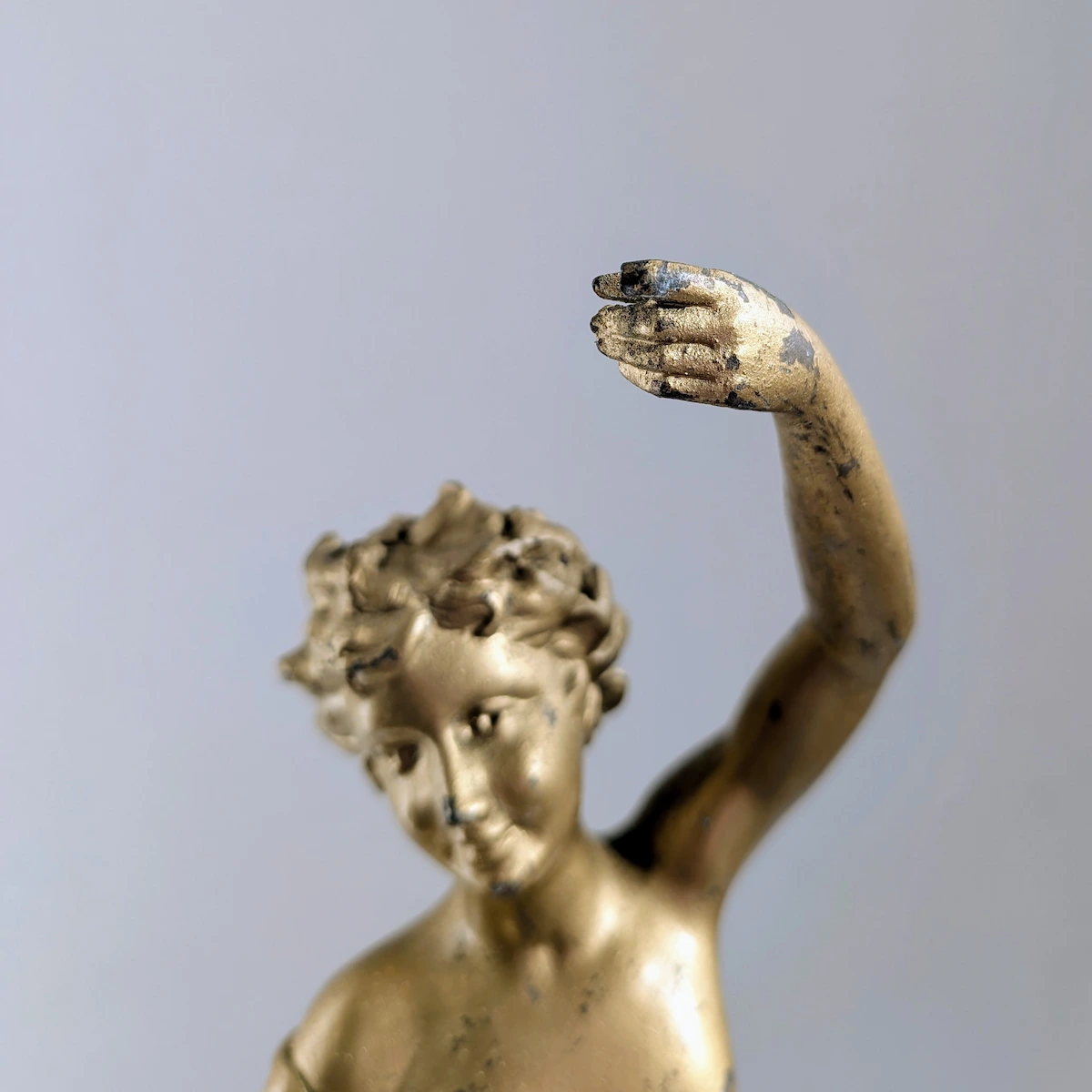 Détail de la patine dorée et du visage de la statue ancienne