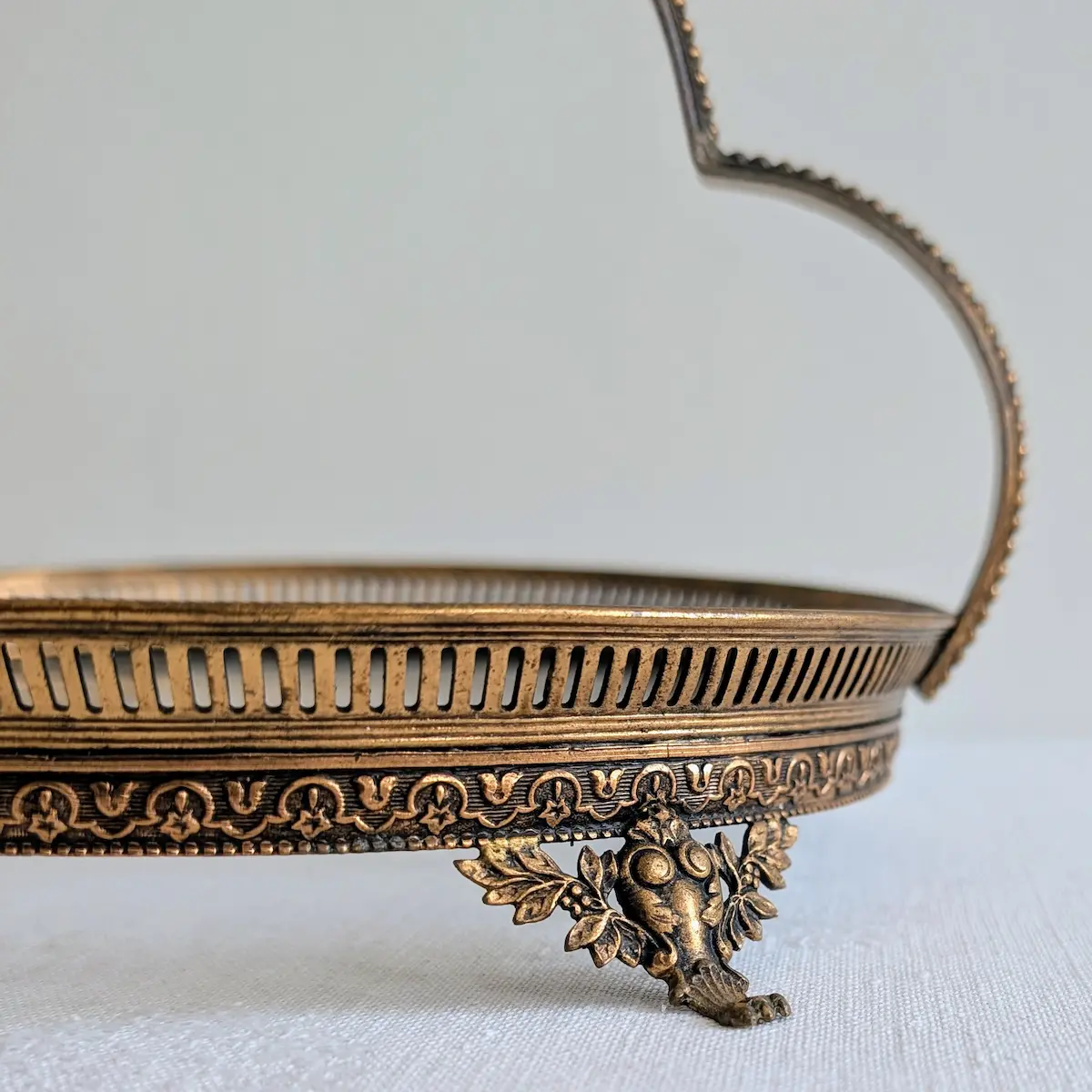 Zoom sur le pied orné de feuillages du serviteur ancien