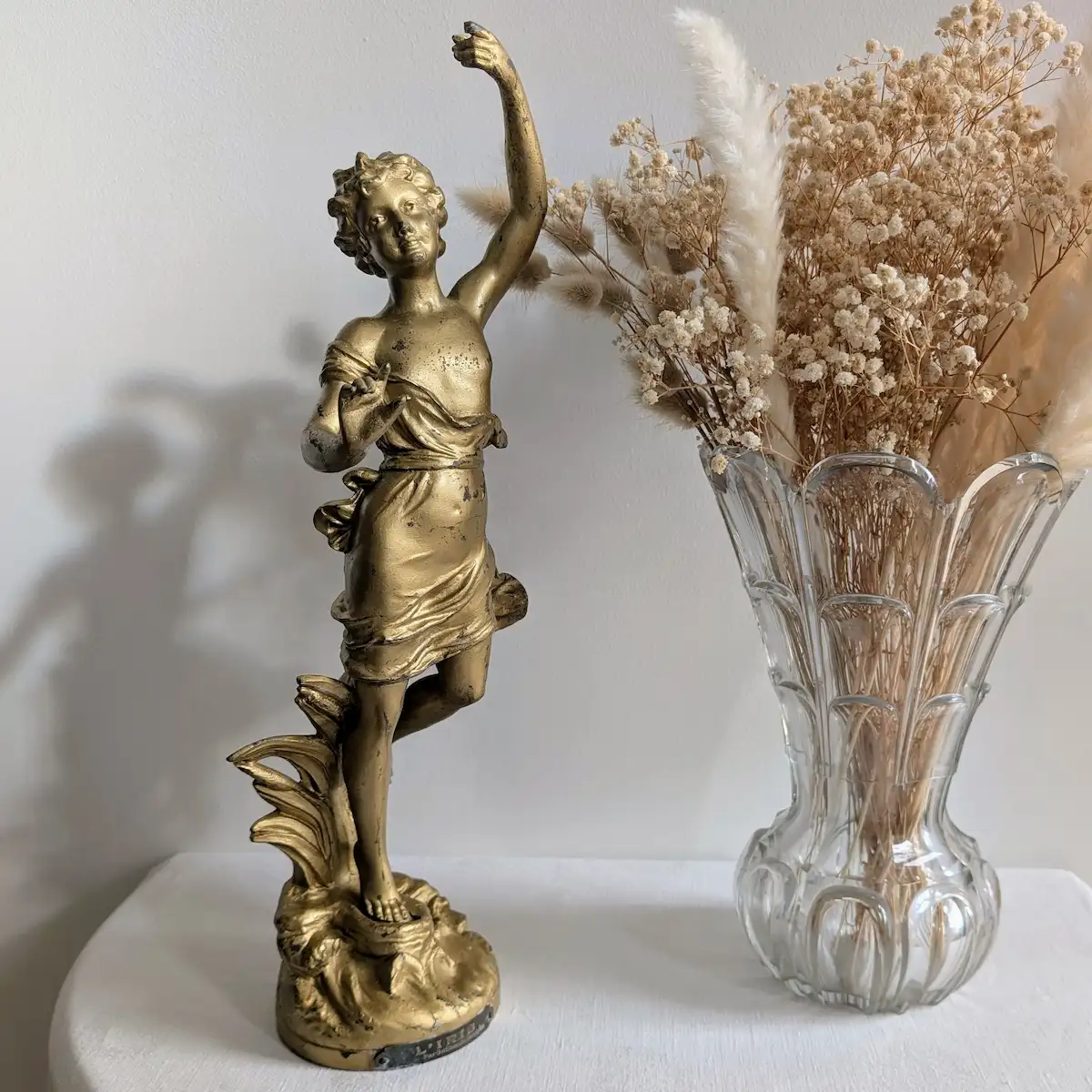 Gros plan sur les motifs de roseaux et feuilles du socle Art Nouveau