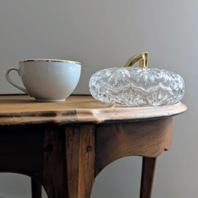 Bonbonnière en cristal posée sur une table ancienne à côté d'une tasse
