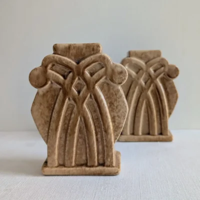 Paire de petits vases en céramique beige style Art Déco avec relief géométrique.