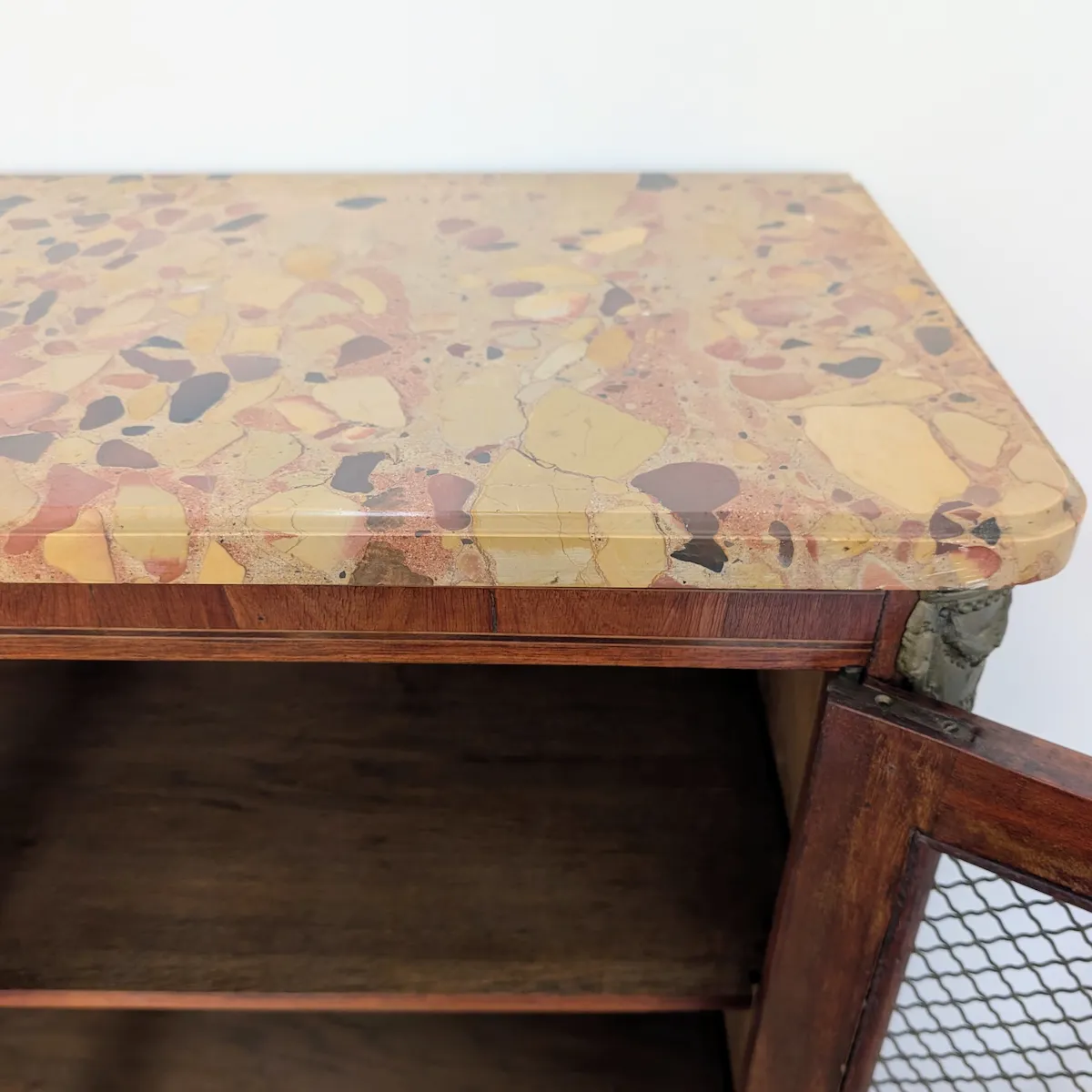 Détail du plateau en marbre naturel veiné ocre et beige d'un meuble ancien