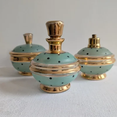 Trio de flacons anciens en verre vert d'eau et dorure pour salle de bain vintage.