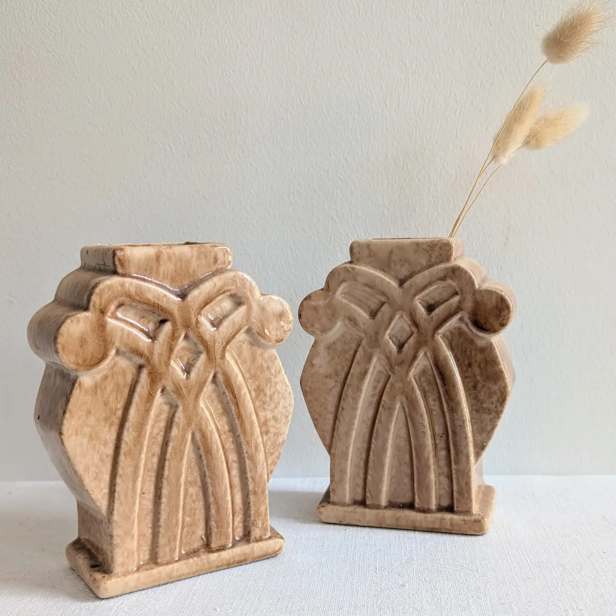 Vue de trois-quarts des vases Art Déco avec graminées séchées.