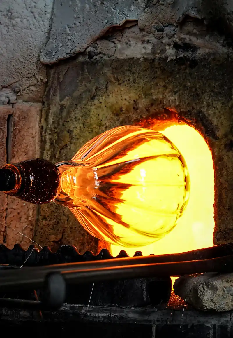 Pièce de verre en fusion à la sortie d'un four de manufacture traditionnelle
