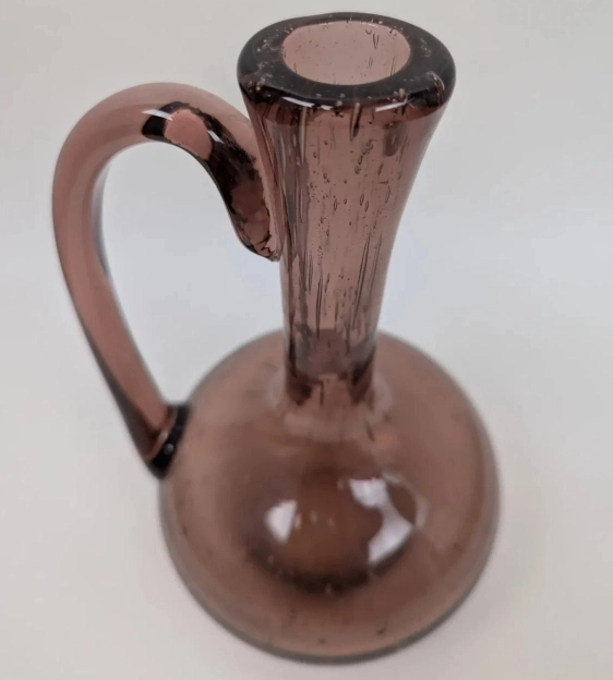 Détail de la finition de l'anse et du col soufflé à la bouche d'une carafe Biot.