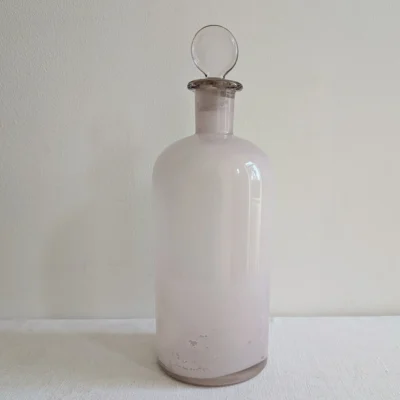 Grand flacon d'apothicaire ancien en verre rosé violassé début XXe avec son bouchon boule d'origine.