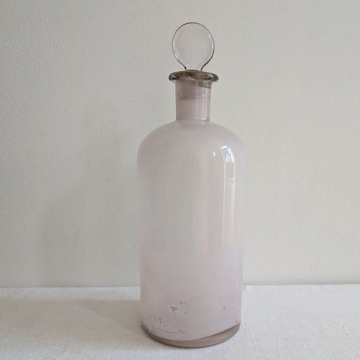 Grand flacon d'apothicaire ancien en verre rosé violassé début XXe avec son bouchon boule d'origine.