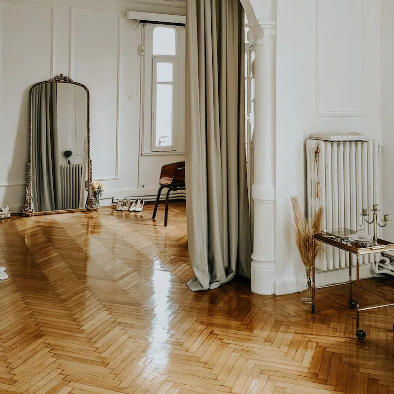 Miroir doré ancien et parquet dans un salon élégant et lumineux
