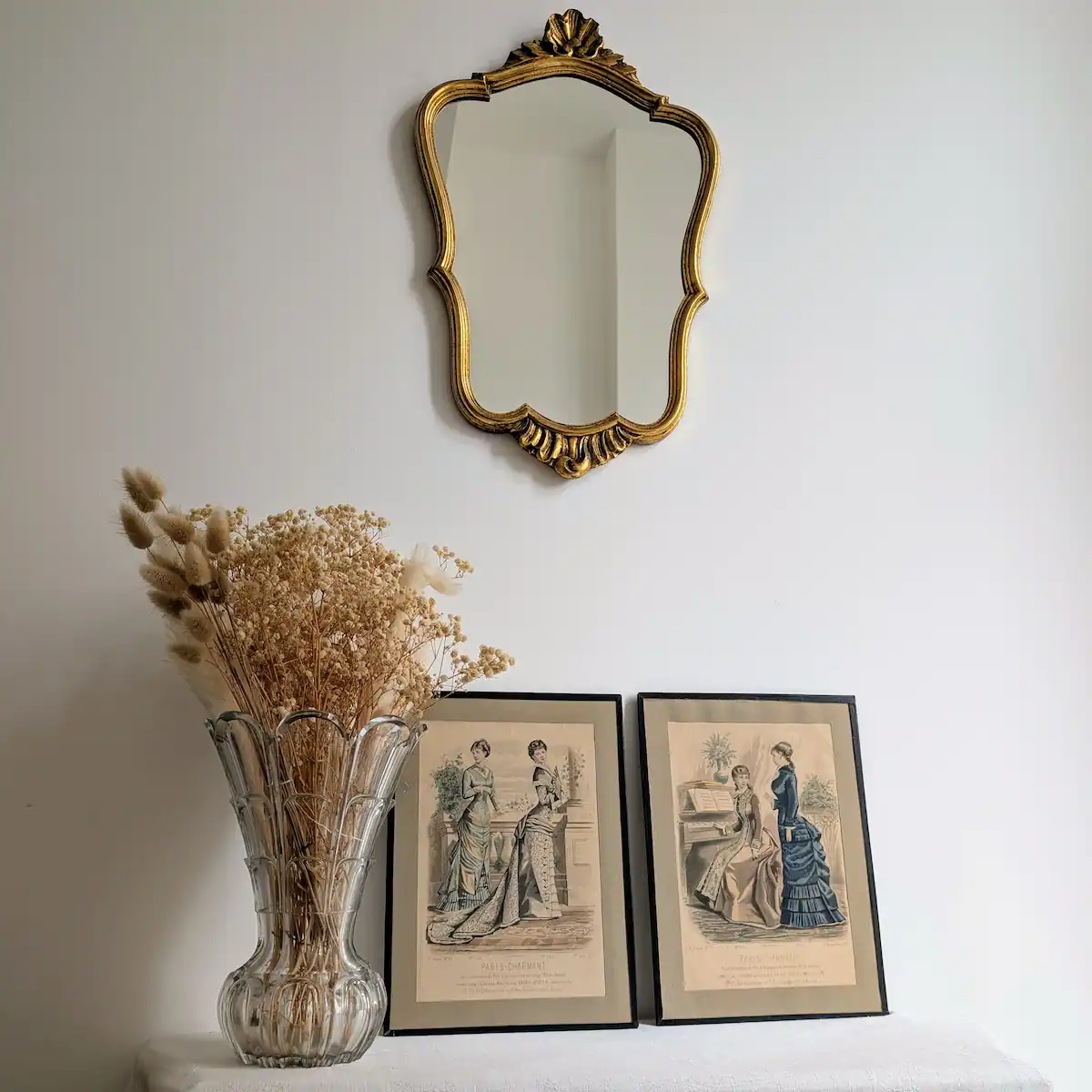 Ambiance décorative avec cadres de mode du XIXe siècle disposés sous un miroir doré