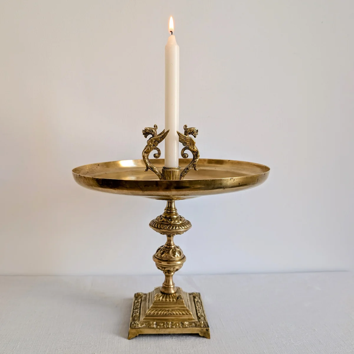 Bougeoir ancien en laiton patiné diffusant une lumière chaleureuse