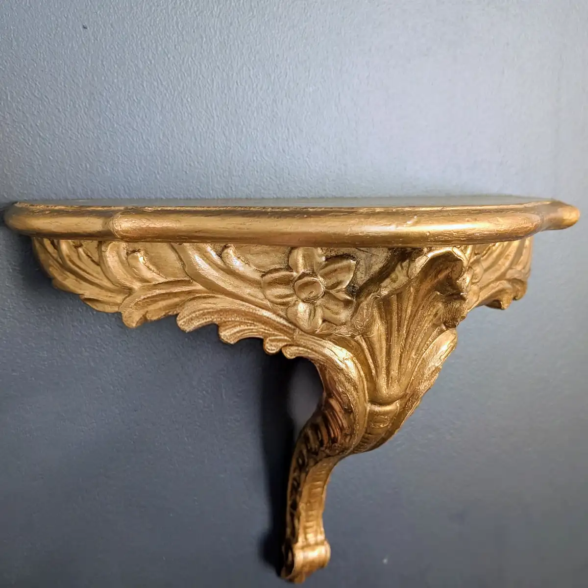 Paire de consoles murales de style Louis XV en bois doré fixées sur un mur