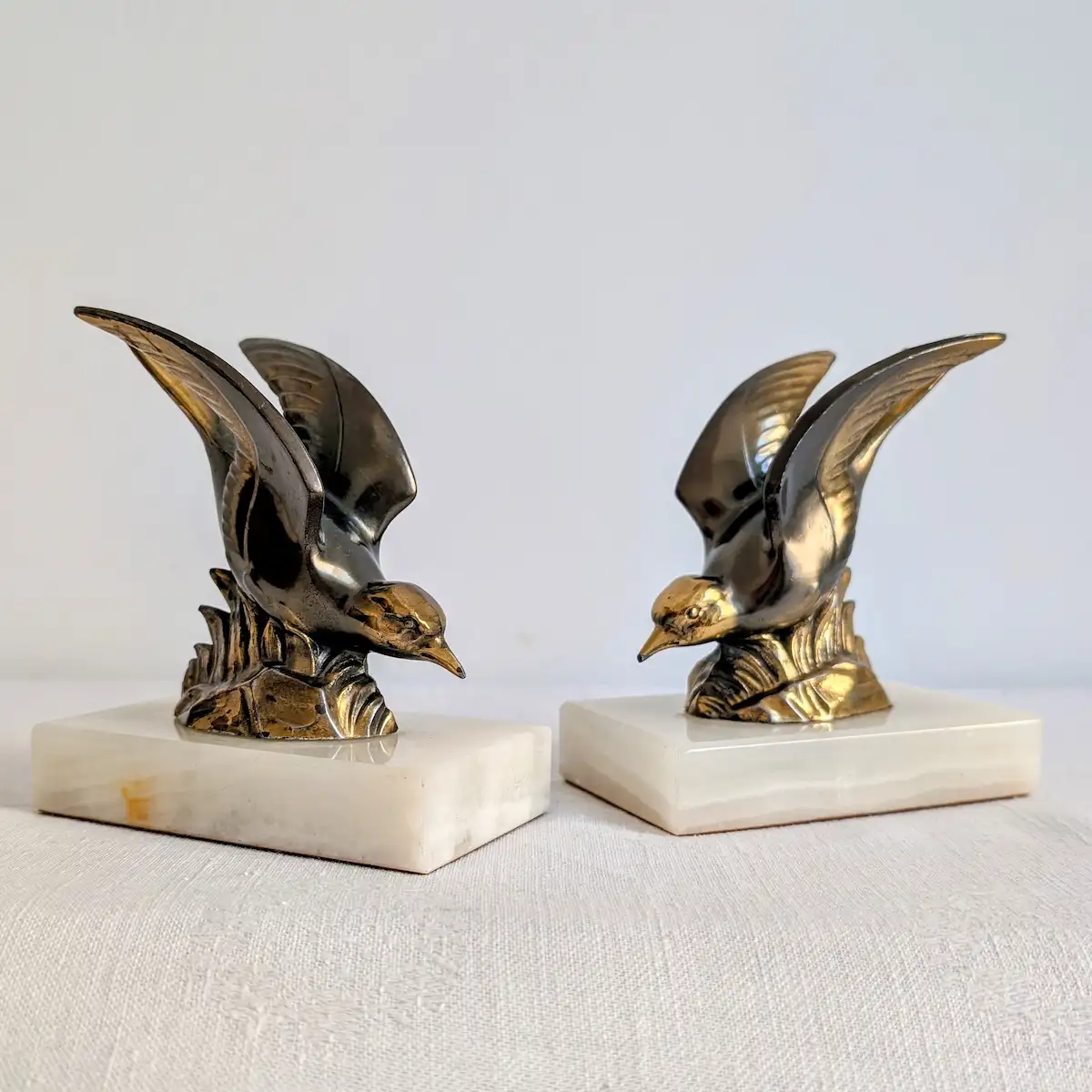 Paire de serre-livres oiseaux en métal doré et socle onyx Art déco