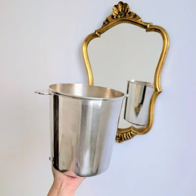 Seau à champagne de collection Ercuis devant un miroir