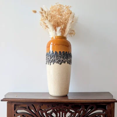 Vase en céramique allemande vintage posé sur une console avec des fleurs séchées