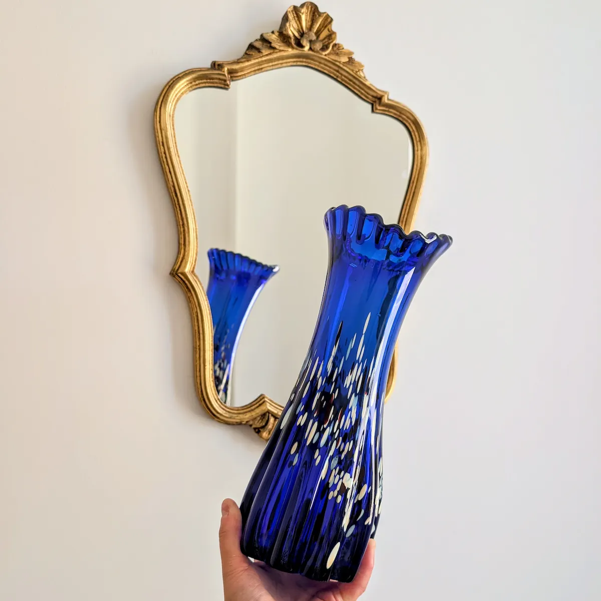 Vase bleu cobalt devant miroir doré