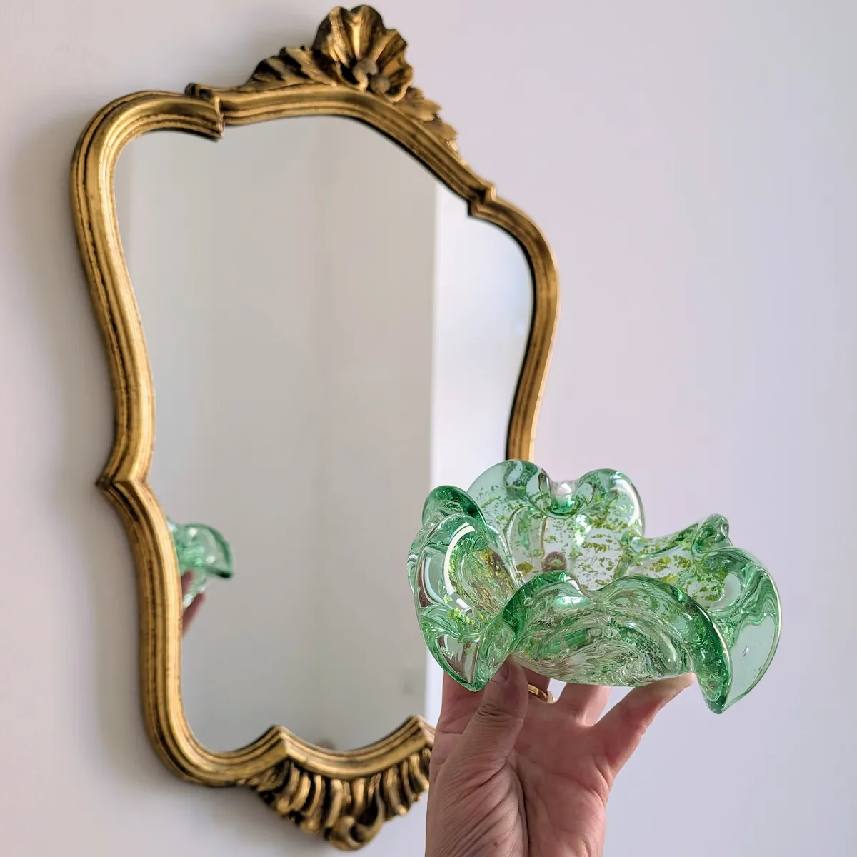 Vide-poche Murano posé devant un miroir doré vintage