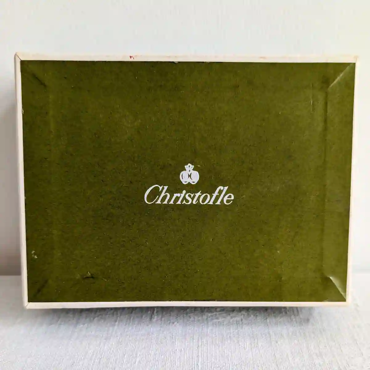 Couvercle de la boîte en carton vert estampillé du logo orfèvre Christofle