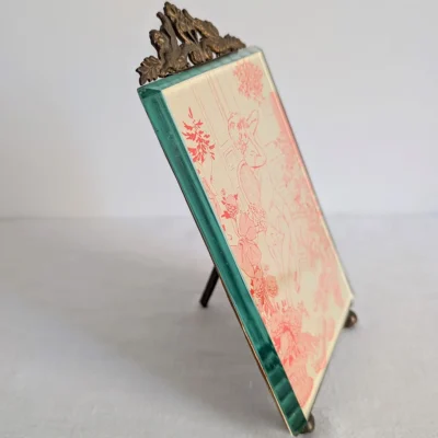Vue de profil d'un cadre photo ancien en verre biseauté clair et monture laiton