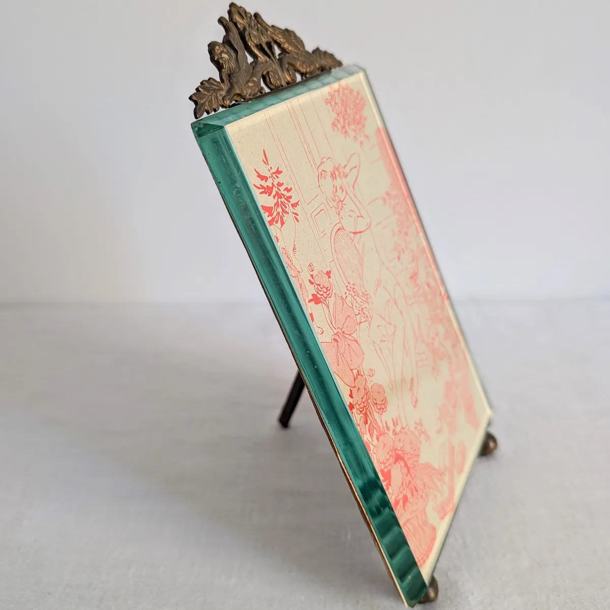 Vue de profil d'un cadre photo ancien en verre biseauté clair et monture laiton