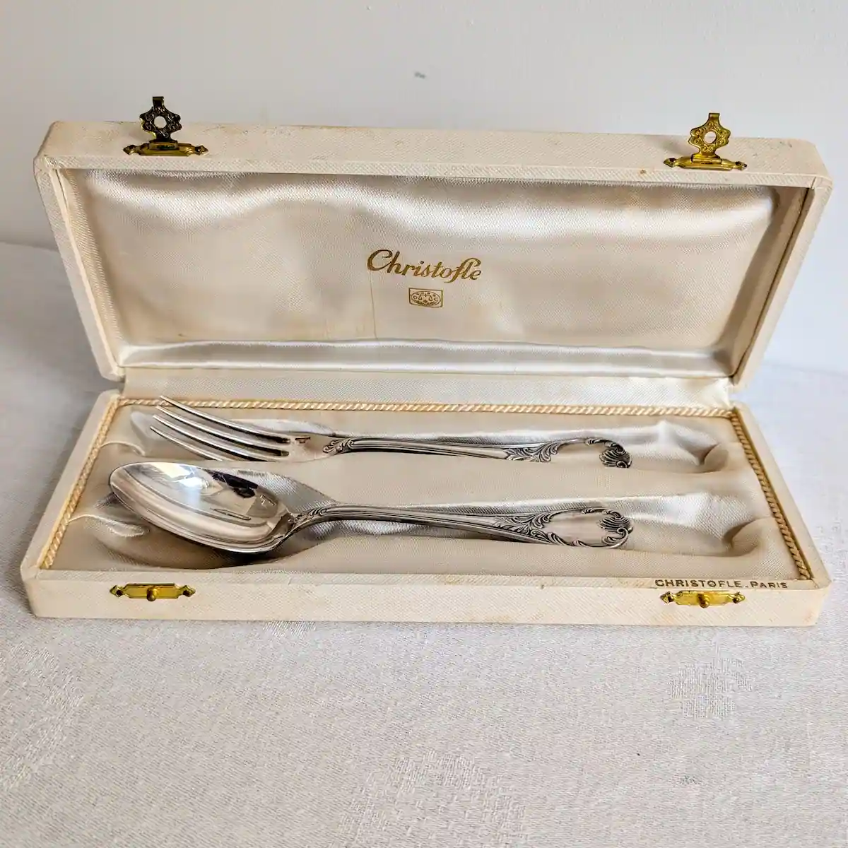 Coffret de naissance Christofle ouvert avec cuillère et fourchette anciennes dans leur écrin d'origine