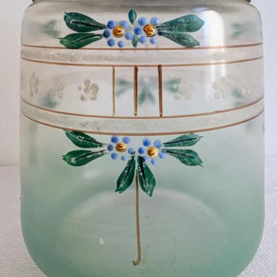 Gros plan sur les fleurs émaillées bleues et dorées peintes sur verre vert d'eau
