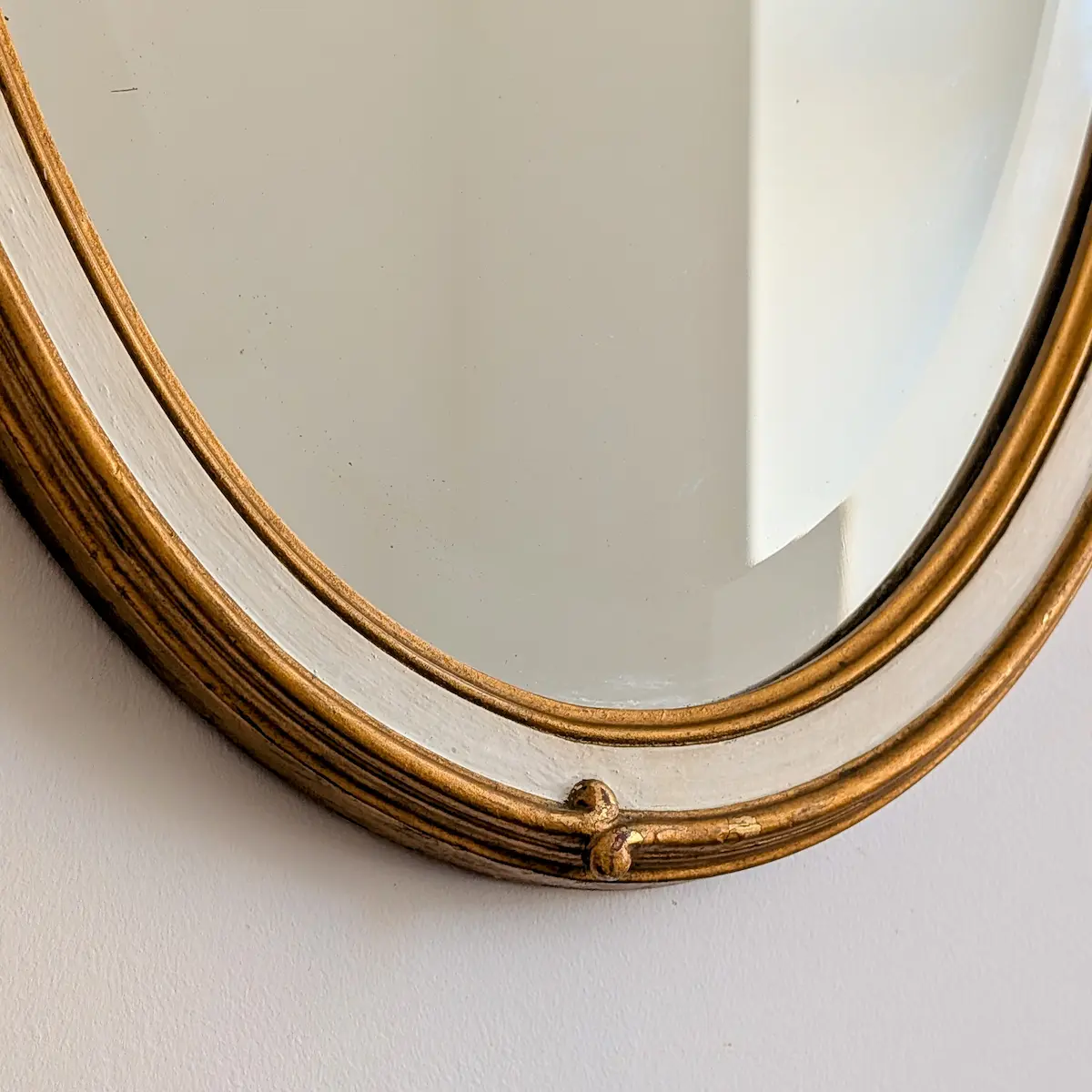 Gros plan sur les cabochons et la dorure patinée du miroir de coiffeuse ancien