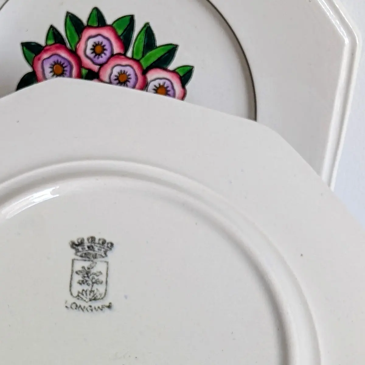 Tampon au blason couronné estampillé au revers d'une assiette dessert Longwy faïence