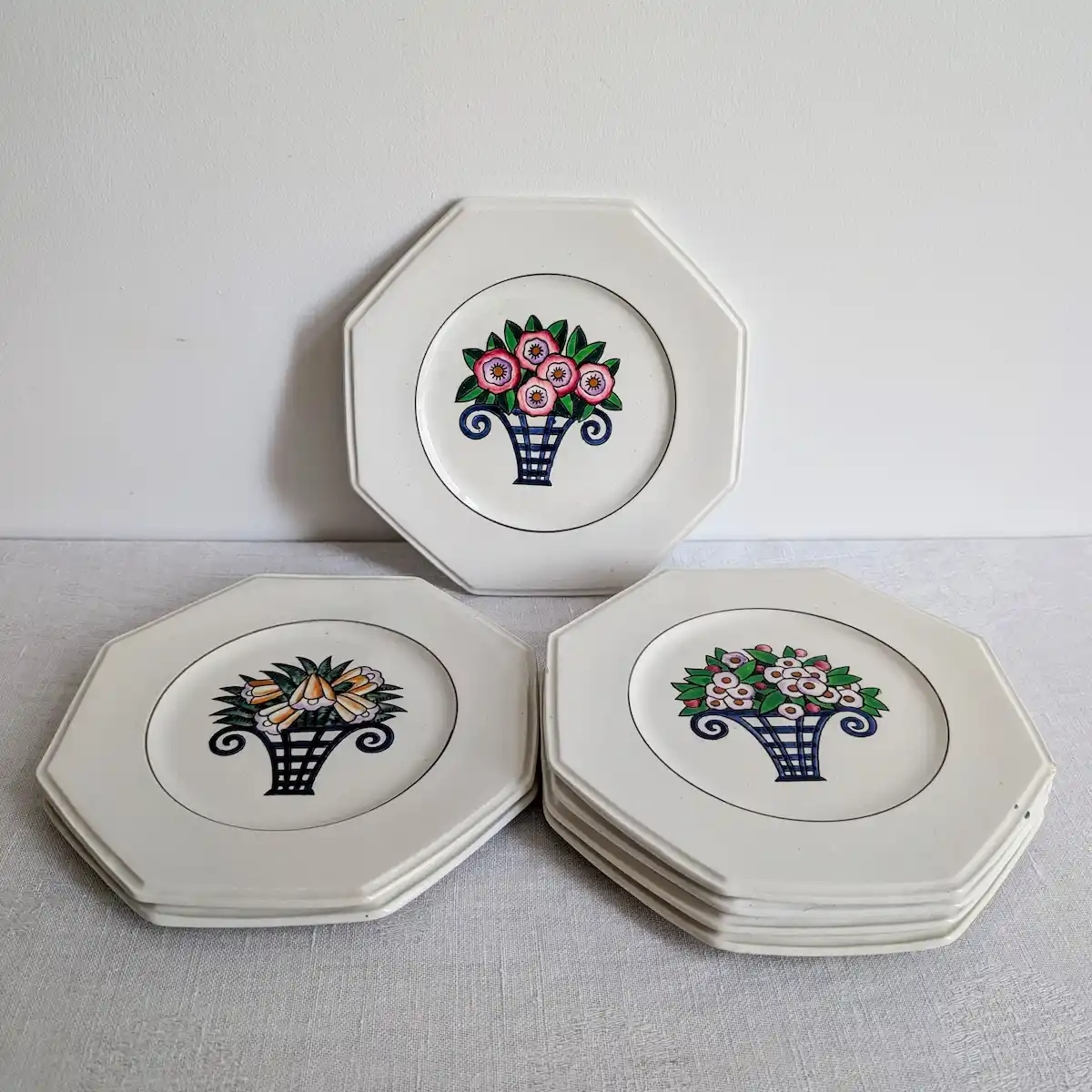 Ensemble de 7 assiettes dessert Longwy faïence octogonales disposées sur table