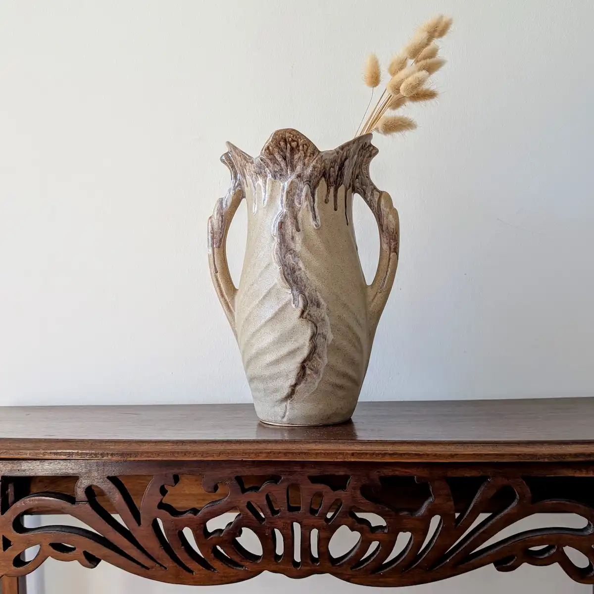 Vase en céramique de Vallauris posé sur une console en bois sculpté
