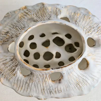 Intérieur ajouré et trous du pique-fleurs en céramique artisanale