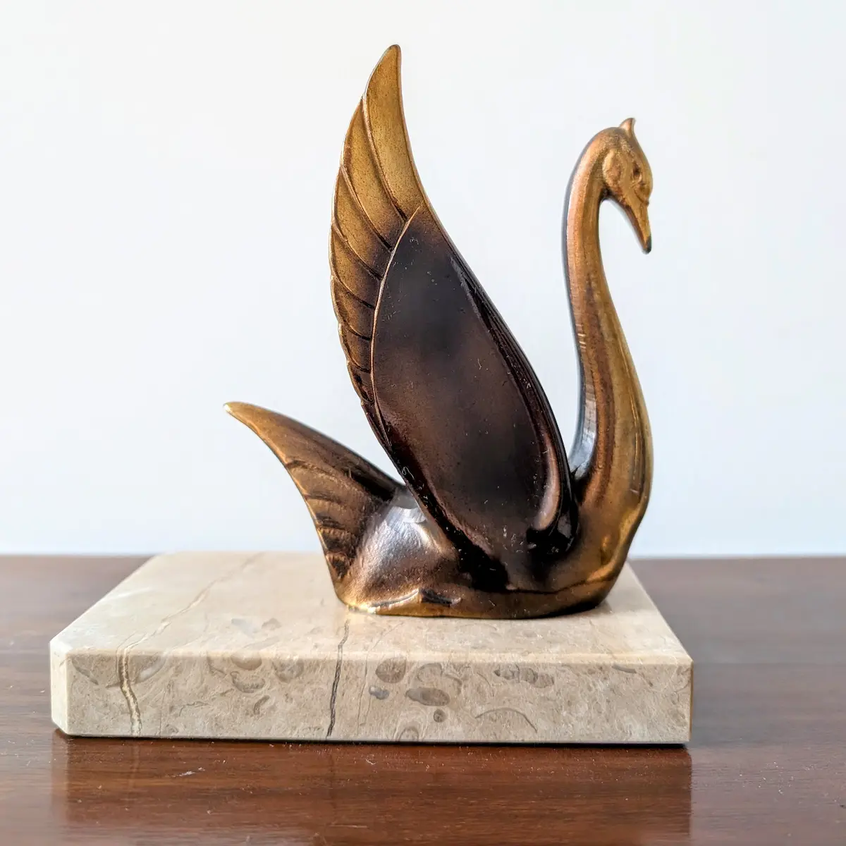 Vue individuelle d'un serre-livres cygne Art déco posé sur son socle rectangulaire en marbre