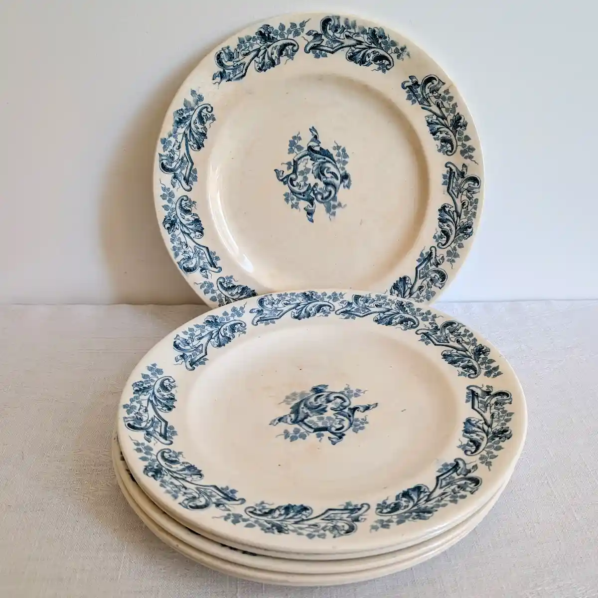 Empilement d'assiettes plates Longwy modèle Russe et détail de la frise bleue