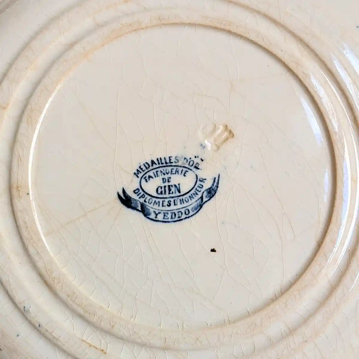 Cachet de la manufacture de Gien au dos d'une assiette avec mentions d'or