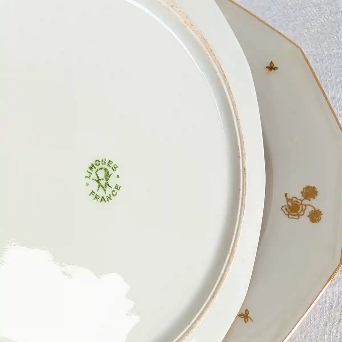 Gros plan sur le tampon vert d'origine Limoges France au dos de l'assiette ancienne