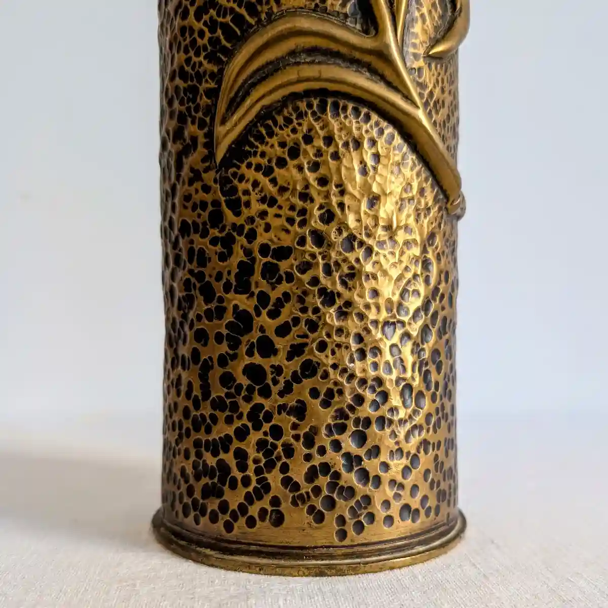 Base et texture du martelage artisanal sur douille d'obus en laiton