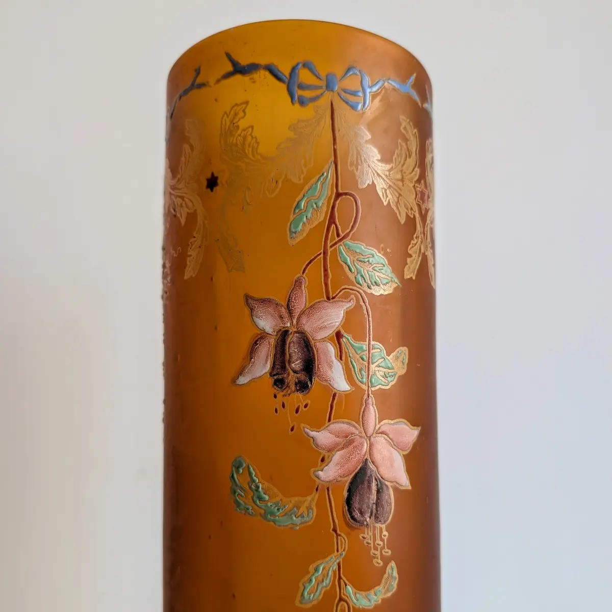 Gros plan sur le col du vase art nouveau avec ruban bleu et émaux polychromes