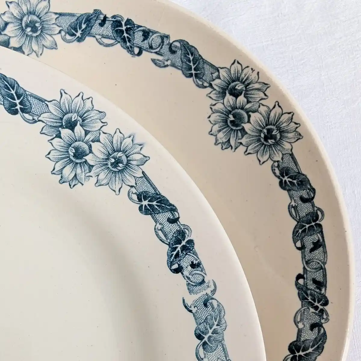 Détail du décor imprimé bleu, rubans et feuillages sur faïence ivoire Longchamp Denise