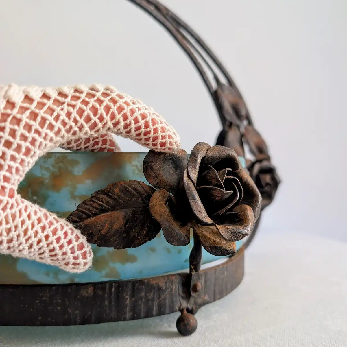 Détail de la rose principale en fer forgé patiné sur la vasque de la jardinière ancienne