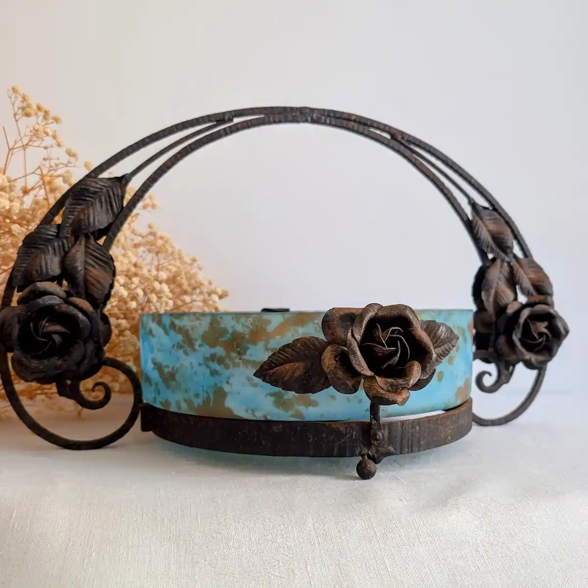 Détail de la patine ancienne et des roses en fer forgé sur fond de fleurs séchées