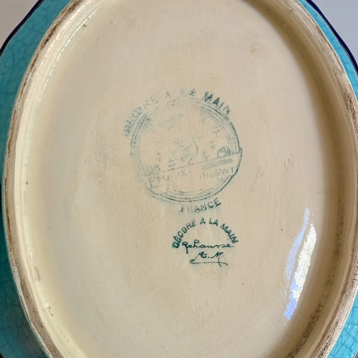 Revers du plat avec cachet Longwy France partiellement effacé, mention décoré à la main et usure du pied