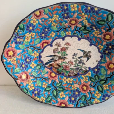 Vue rapprochée des deux oiseaux et des craquelures de la réserve crème du plat Longwy