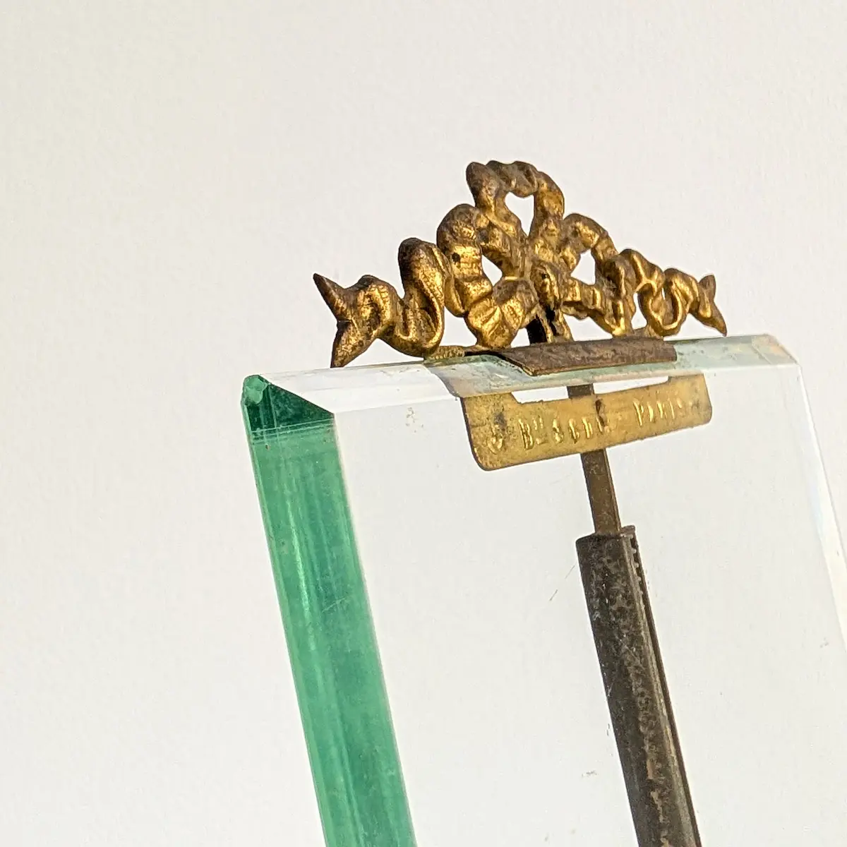 Détail de la tranche du verre biseauté et de la patine de laiton