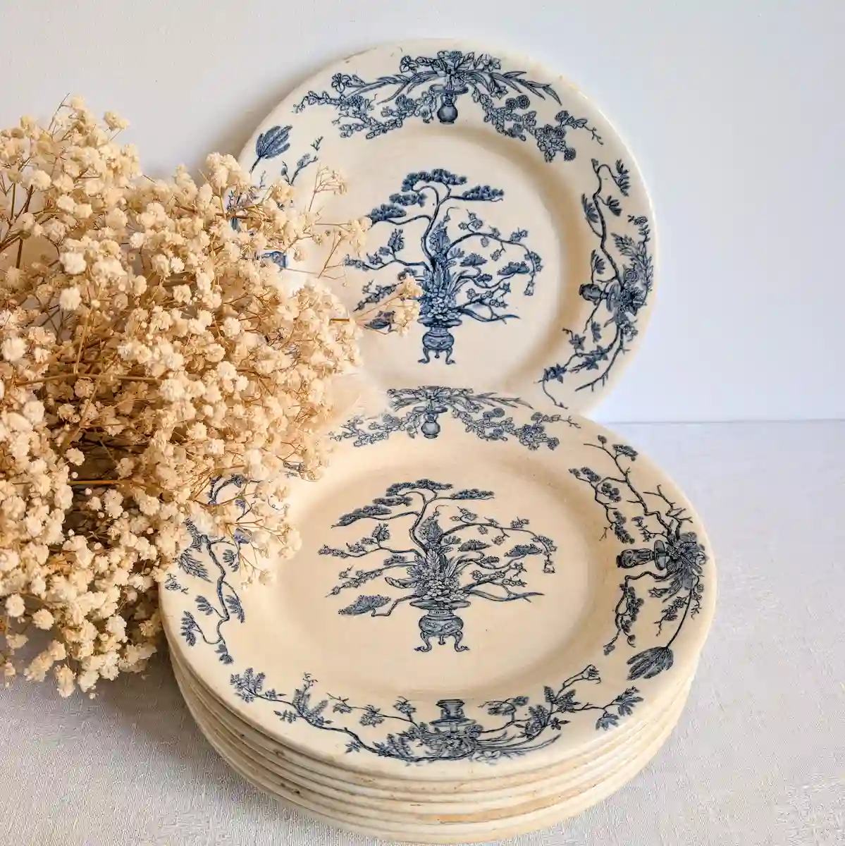 Service de neuf assiettes Gien Yeddo avec un bouquet de fleurs séchées