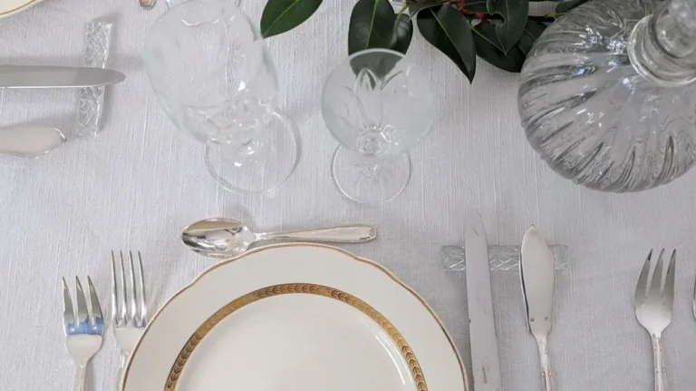 Vaisselle ancienne avec assiette à liseré doré, verrerie en cristal et couverts argentés