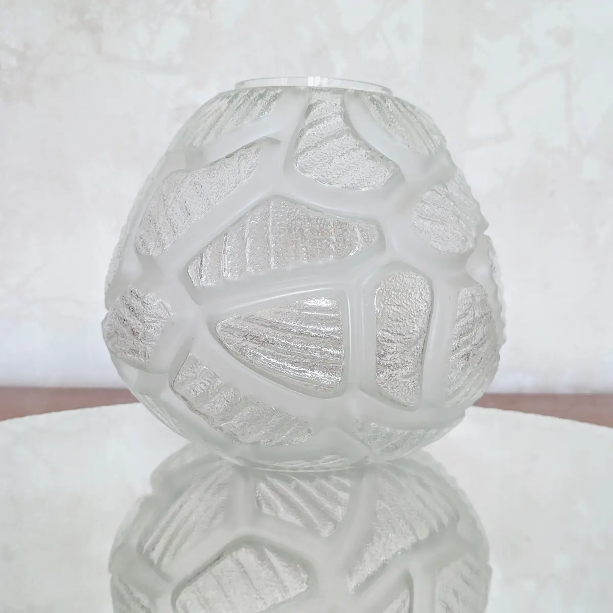 Vue de profil d'un vase ancien en verre texturé mettant en valeur ses reflets lumineux