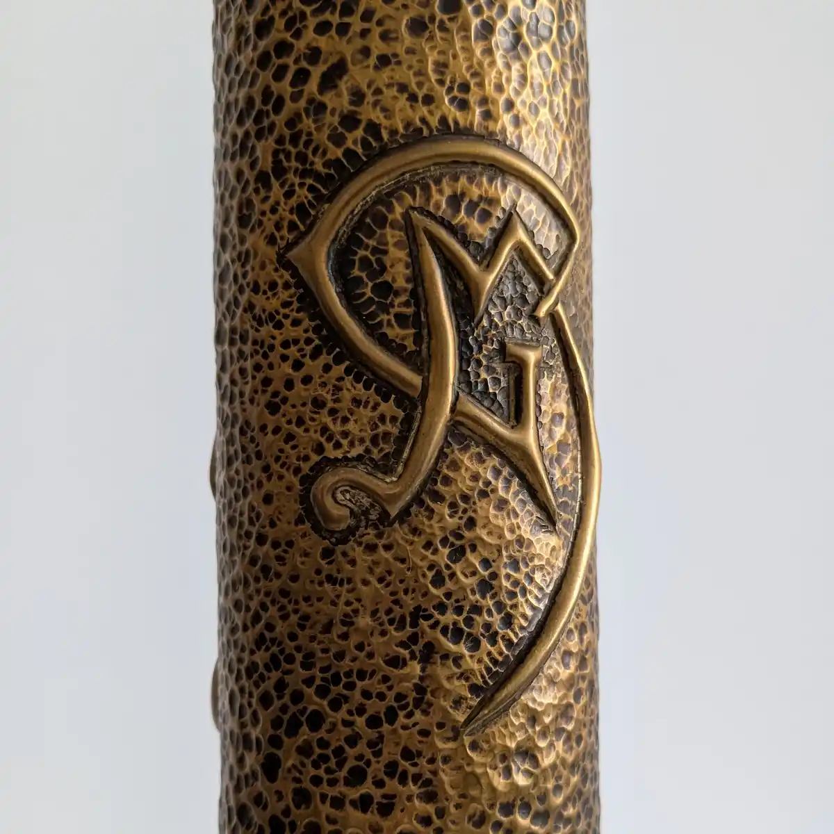 Monogramme GM entrelacé gravé sur vase en douille d'obus ancienne