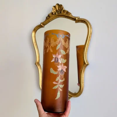 Vase art nouveau en verre ambré présenté devant un miroir ancien doré
