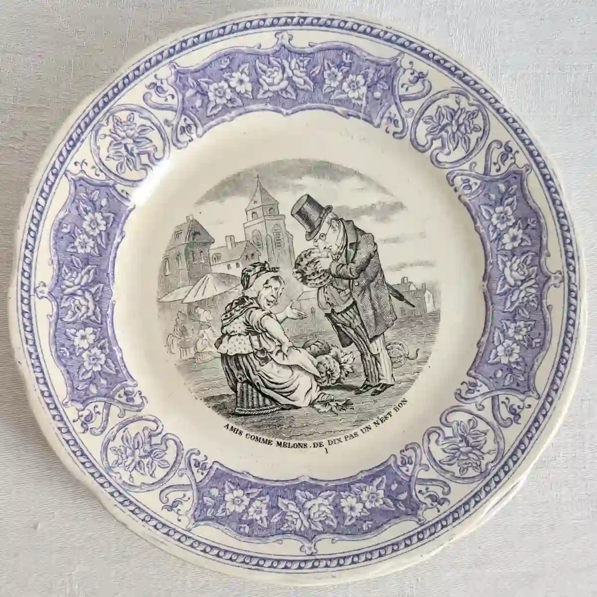 Assiette ancienne numéro 1 montrant une marchande de melons et un homme en haut-de-forme sur une place de marché.