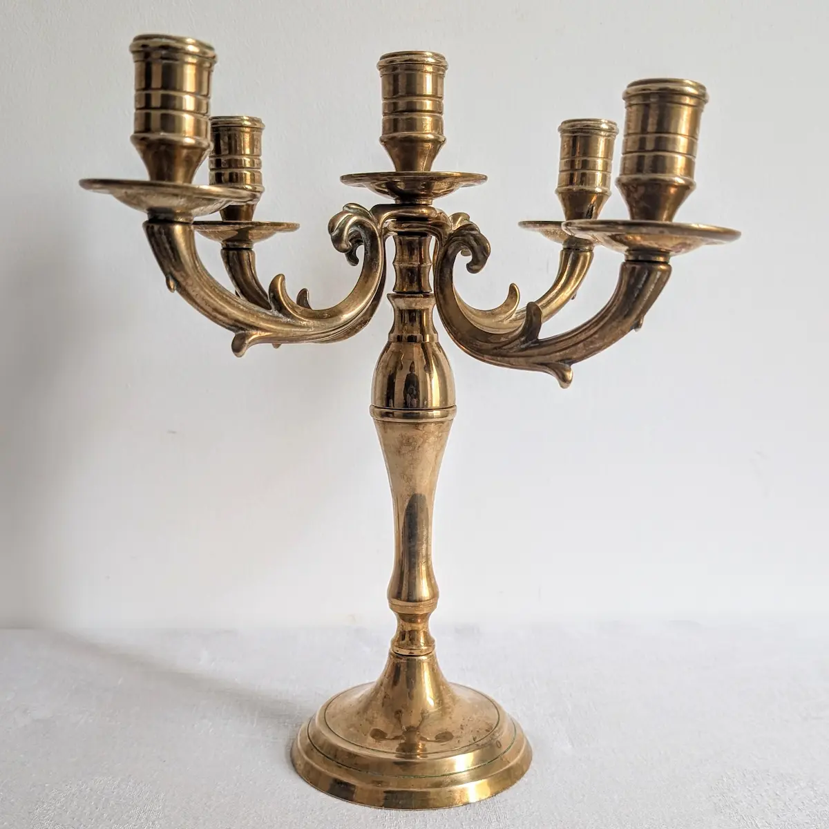 Chandelier à cinq feux en laiton patiné, avec bras en volutes et base ronde